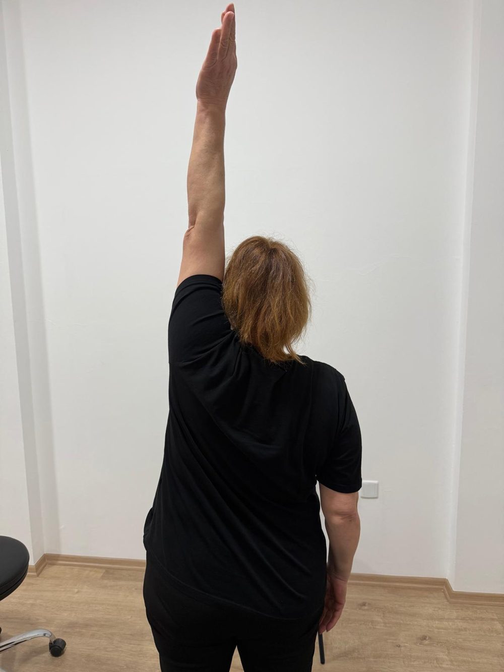 The same patient after the session, arm raised fully overhead